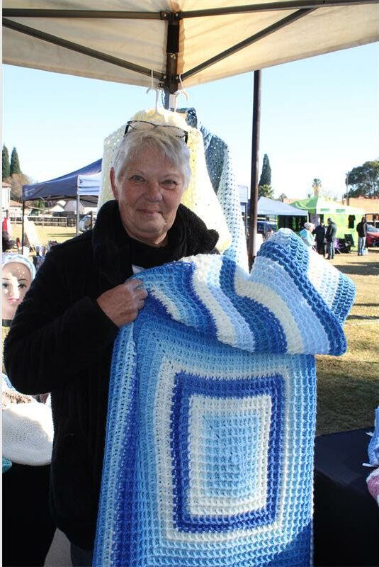 Eldely woman holding a blue woolen blanket