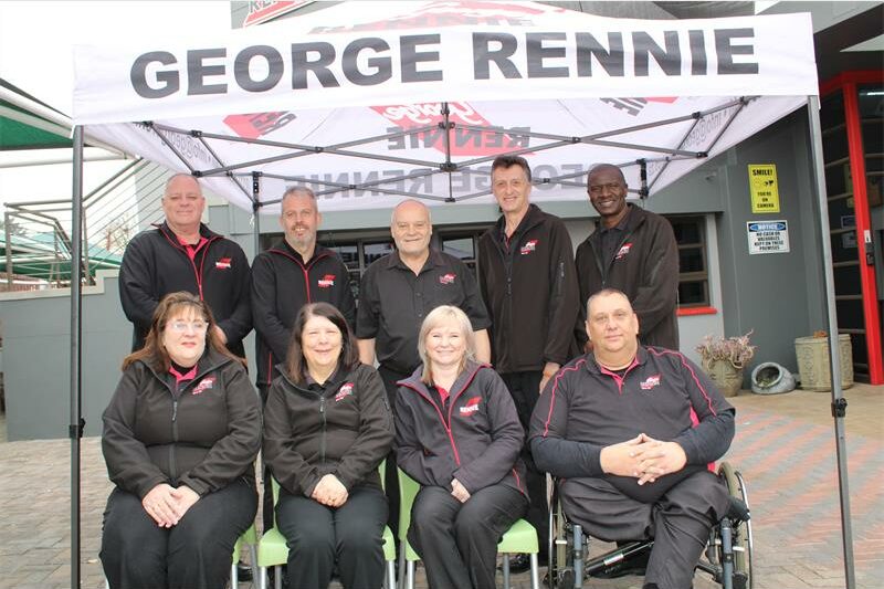 Group of people wearinf matching black jackets sitting under a George Rennie gazebo