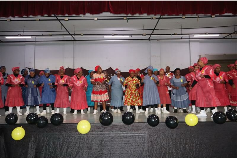 Black women in colourful attire dancing on stage