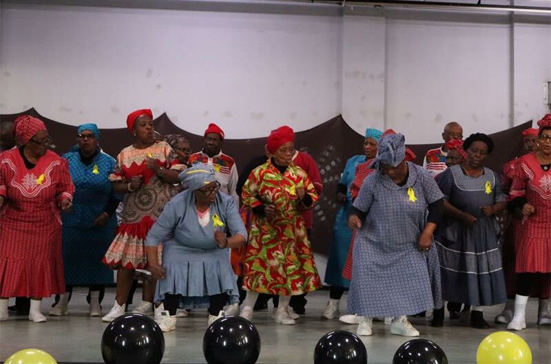 Black women in colourful attire dancing on stage