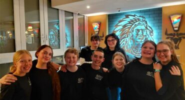 A group of young men and women dressed in black shirts inside a Spur restaurant.