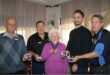 Group of five people, four men and one woman holding medals of honour