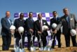 Group of multi-cultural men holding white hard hats and shovels