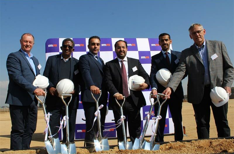 Group of multi-cultural men holding white hard hats and shovels