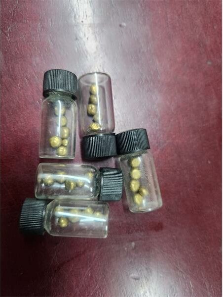 Clear, small plastic bottles with black lids containing small stones.