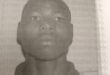 Black and white mug shot of a bald black man