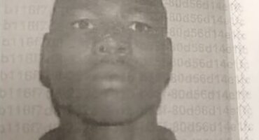Black and white mug shot of a bald black man