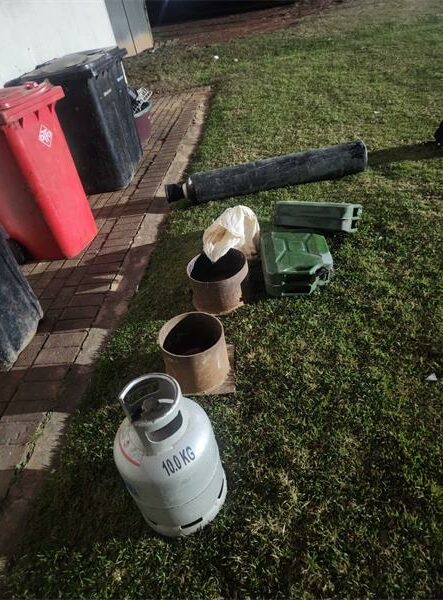 Gas bottles, buckets and other implements used for illegal mining photographed on grass.