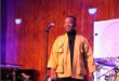 Black man standing on a lit stage