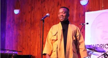Black man standing on a lit stage
