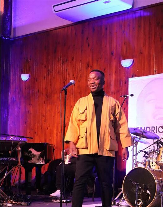 Black man standing on a lit stage