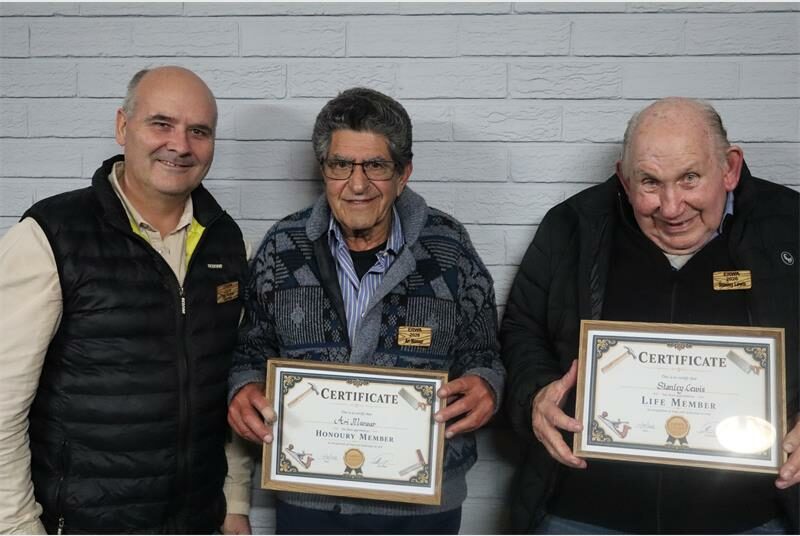 Two men holding certificated standing next to a bald man