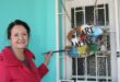 Woman stands holding a paint brush