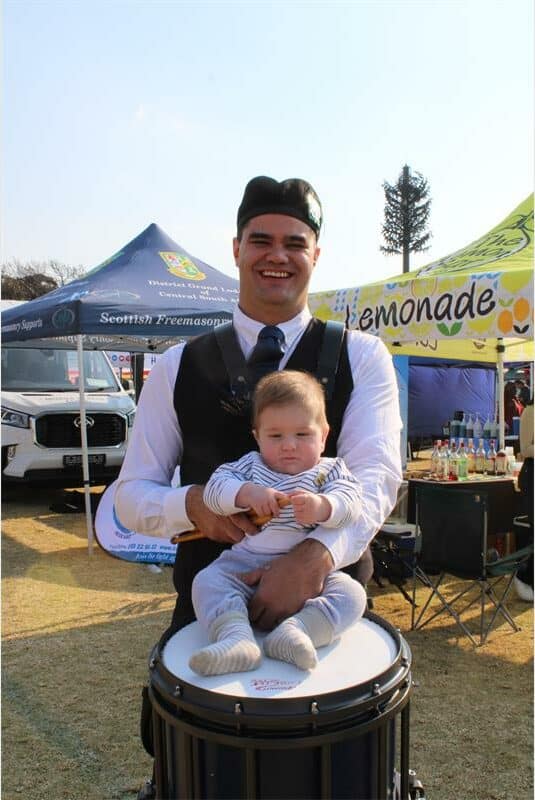 Man balancing a baby on a drum