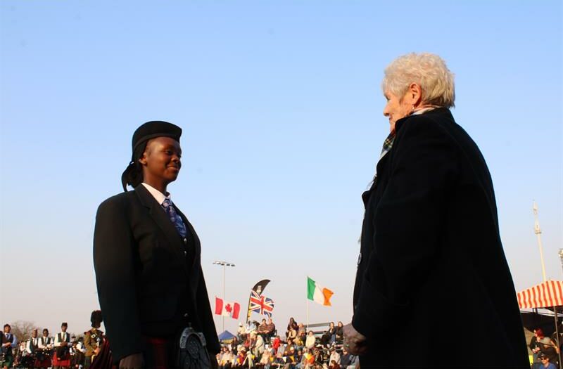 Young black girl standing in front of a grey-haired older woman