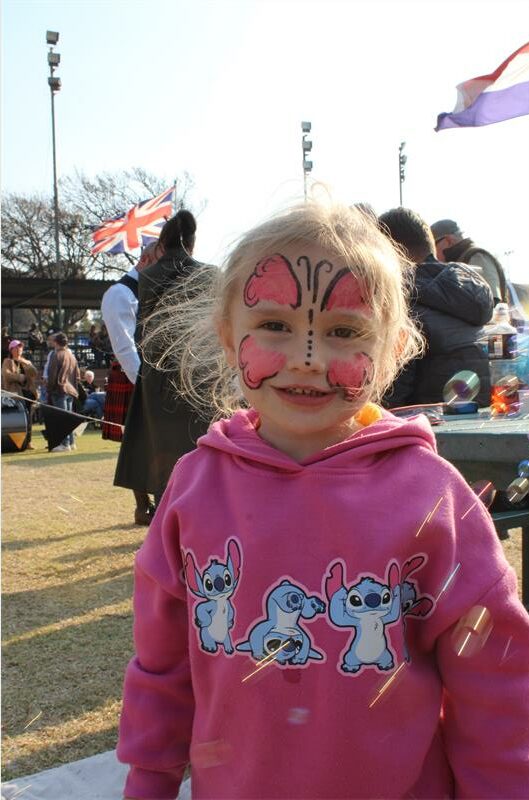 Girl with face paint and bubbles swirling around her