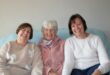 Three women sitting on a couch smiling