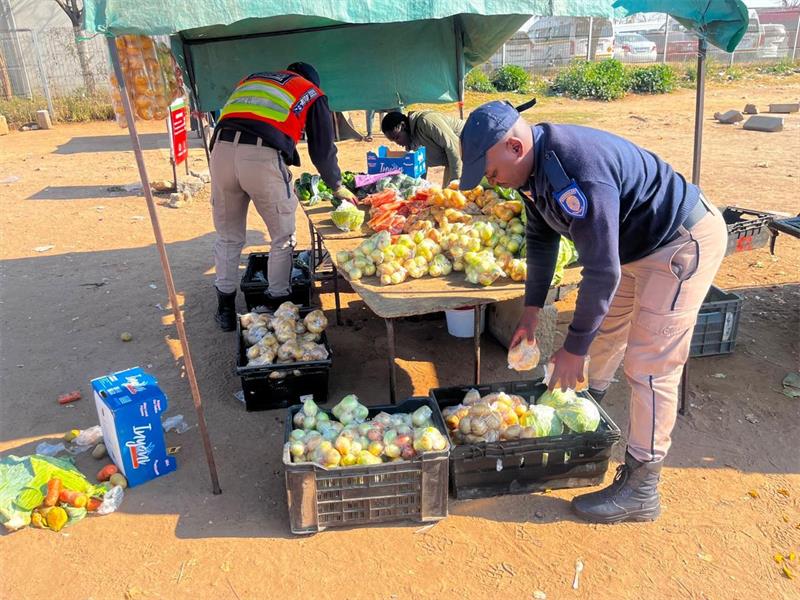 Uniformed officers at a fruit and vegetable stand