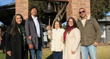 Group of people standing at a bell
