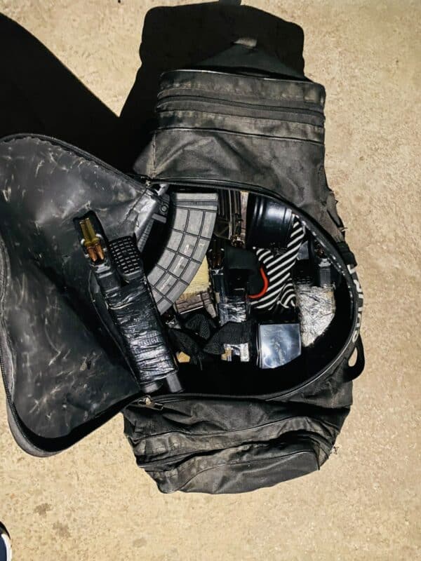 A grey bag unzipped showing various content pieces believed to be for bomb making.