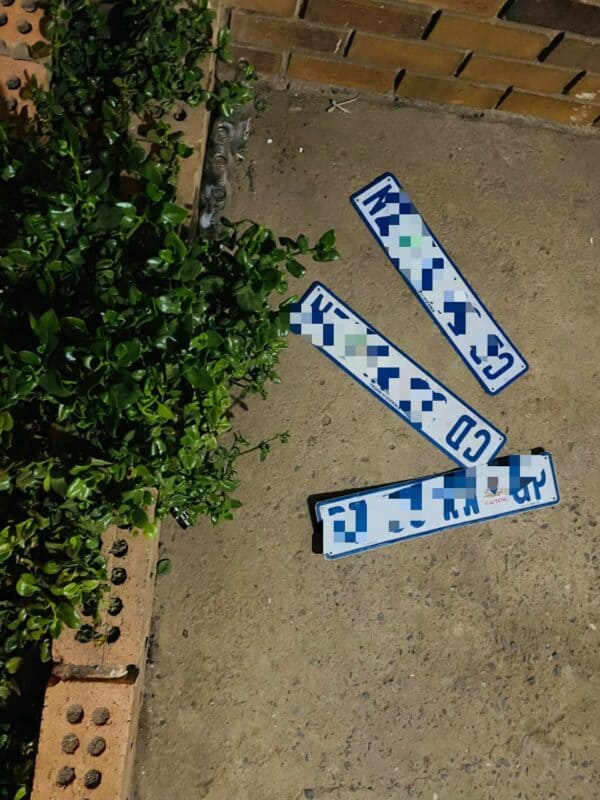 Three registration plates photographed from above on a concrete floor.