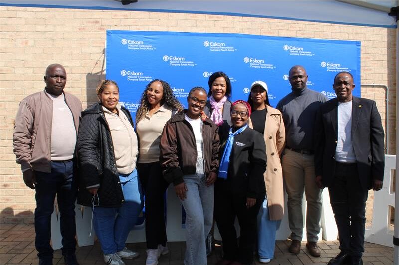 Group of people standing in front of a blue Eskom banner
