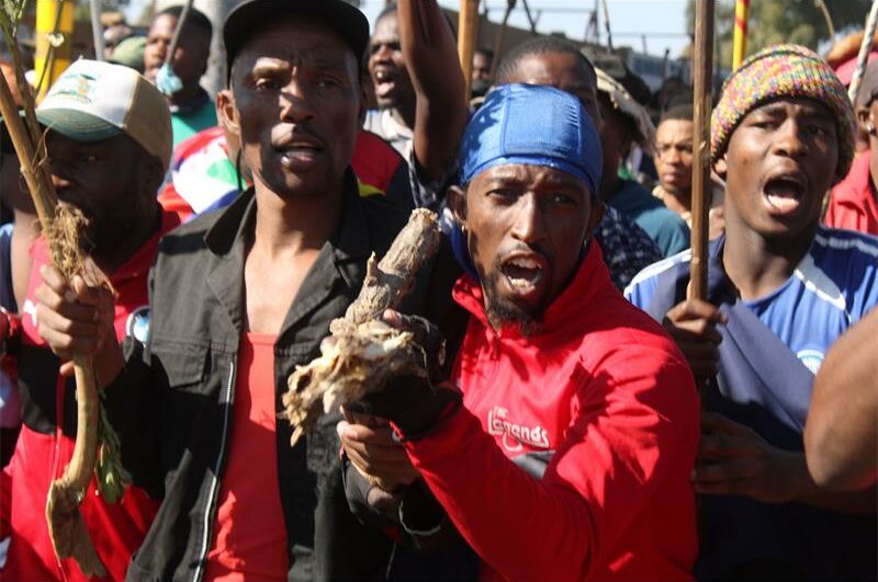 Close-up of two black men who are part of a protest movement, chanting