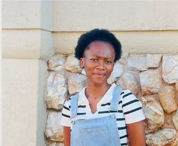 Young black woman standing in front of a wall