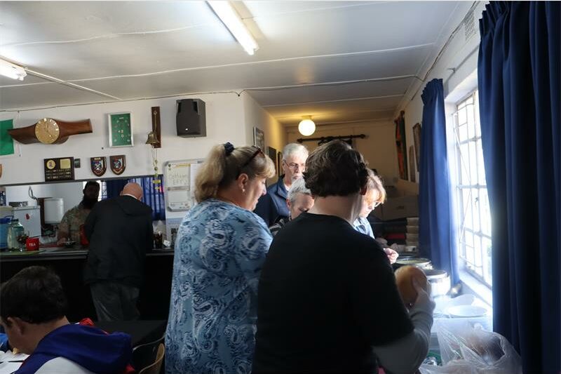 Women with their backs turned to the camera standing over a work bench