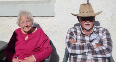 Elderly man and woman sitting in the sun