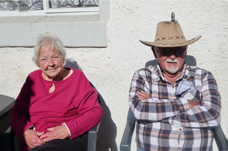 Elderly man and woman sitting in the sun