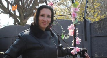 Woman posing next to a flower garland