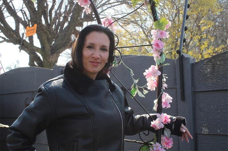 Woman posing next to a flower garland