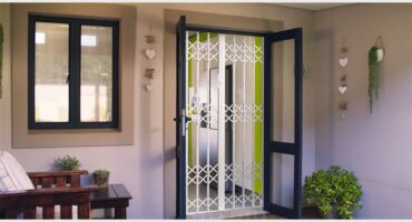 A view of double glass doors taken from inside showing a security gate protecting the home.