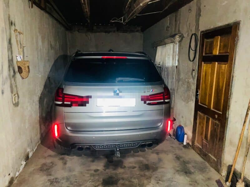 A BMW vehicle parked in a garage and photographed from the back.