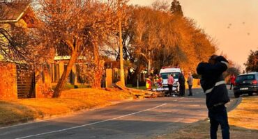 Picture of an ambulance and emergency personnel standing in the road