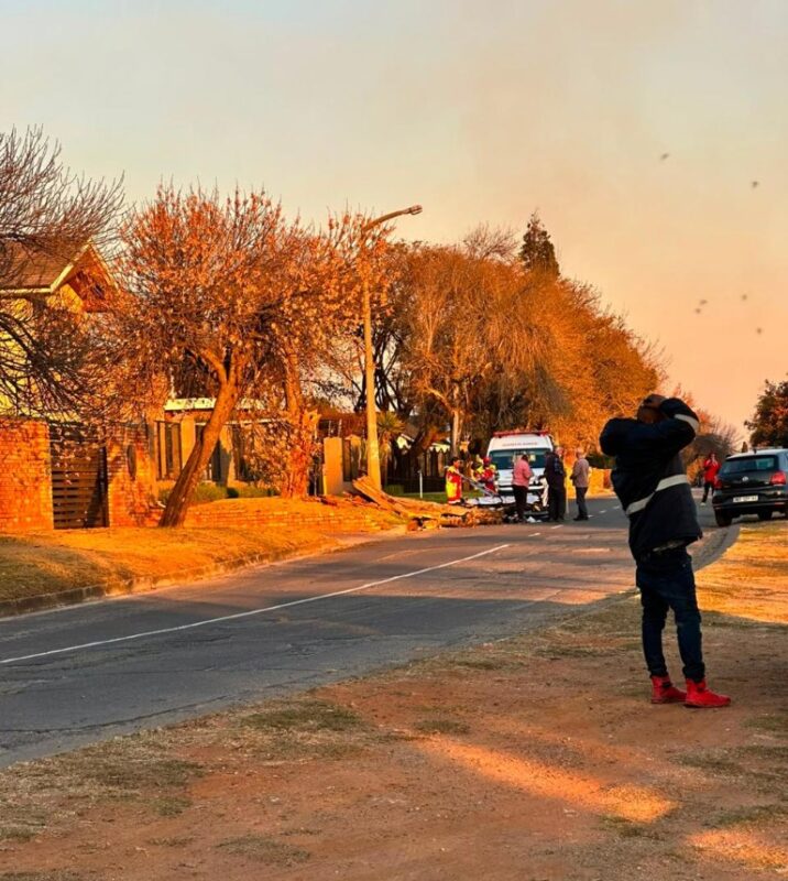 Picture of an ambulance and emergency personnel standing in the road