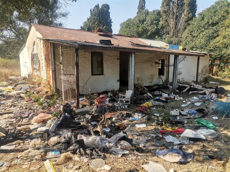 a pile of rubbish next to a crumbling building
