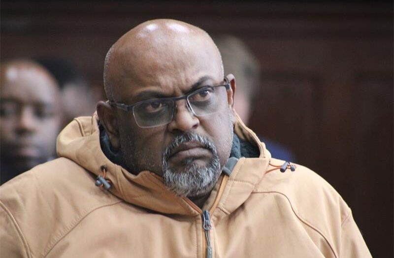 a man wearing a jacket and glasses