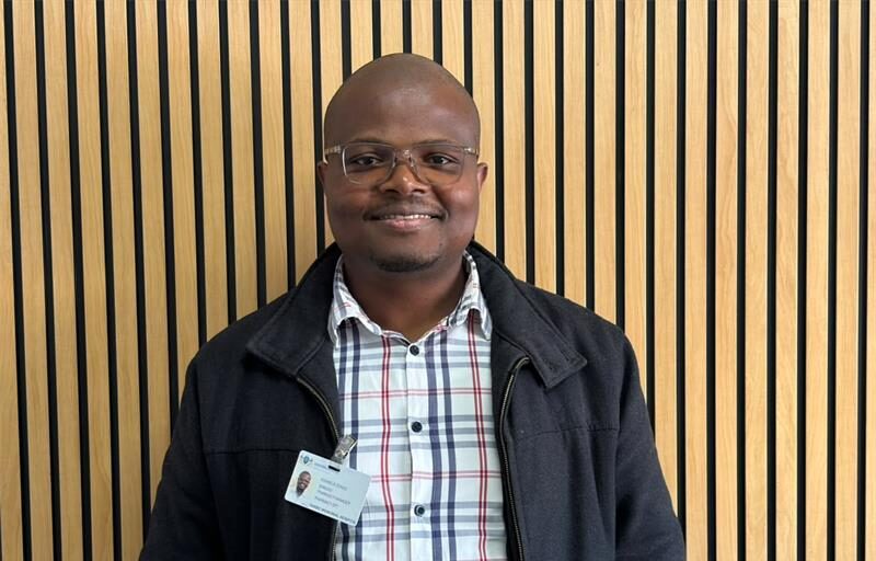 a man standing next to a wall