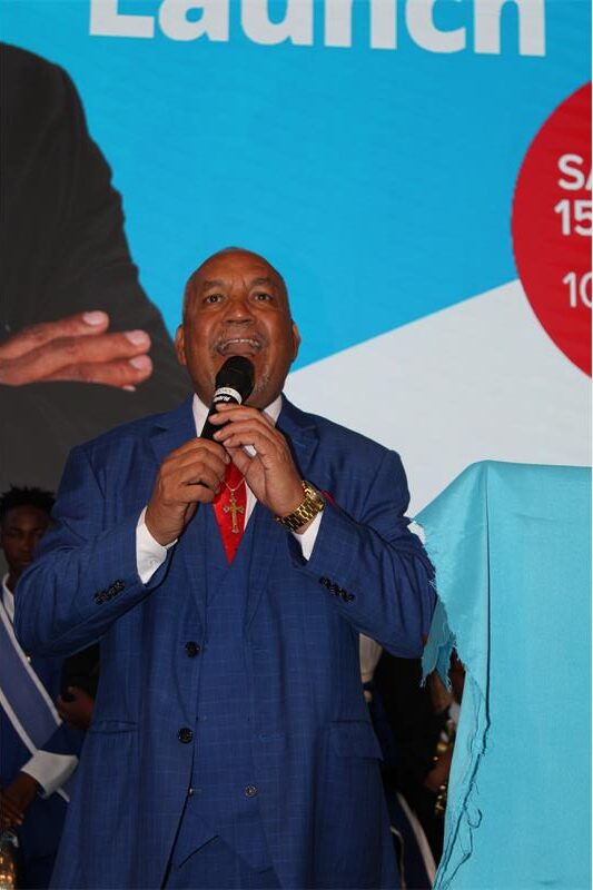 Black man holds a microphone with his mouth open
