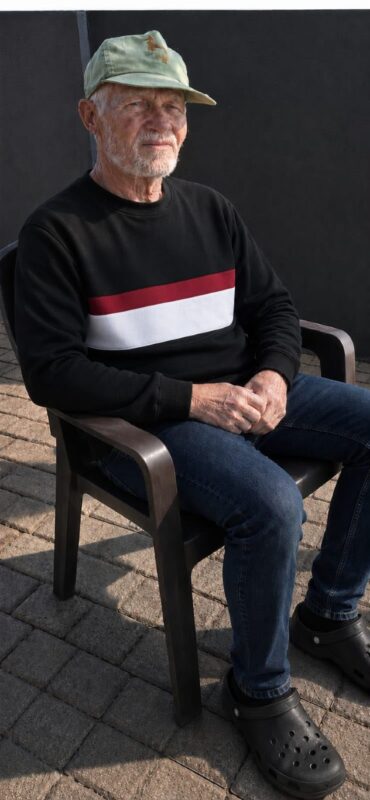Elderly man sitting on a garden chair.