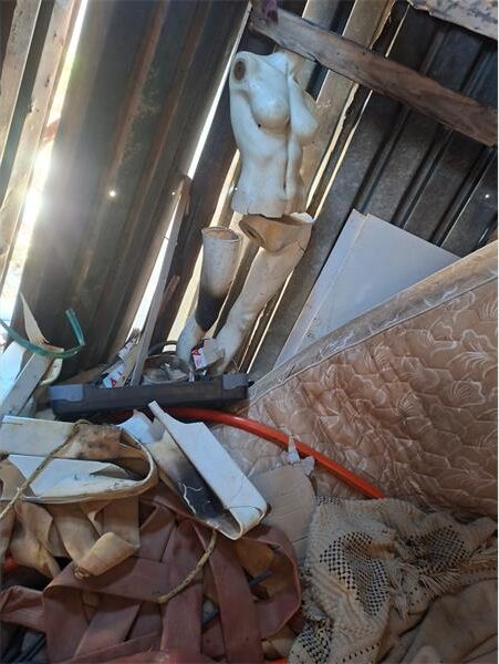 Broken mannequin in a corner of a messy room