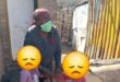 Elderly woman holding two children whose faces are blocked with an emoji