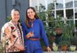 Two white women stand next to a herb garden holding sheers