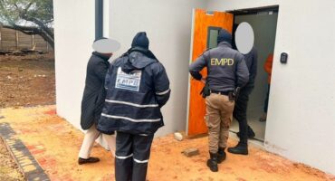 Three people two of which are wearing EMPD uniforms walking into a door