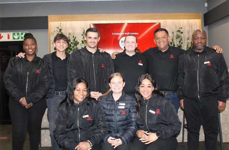 Group of people standing in front of Vodacom signage