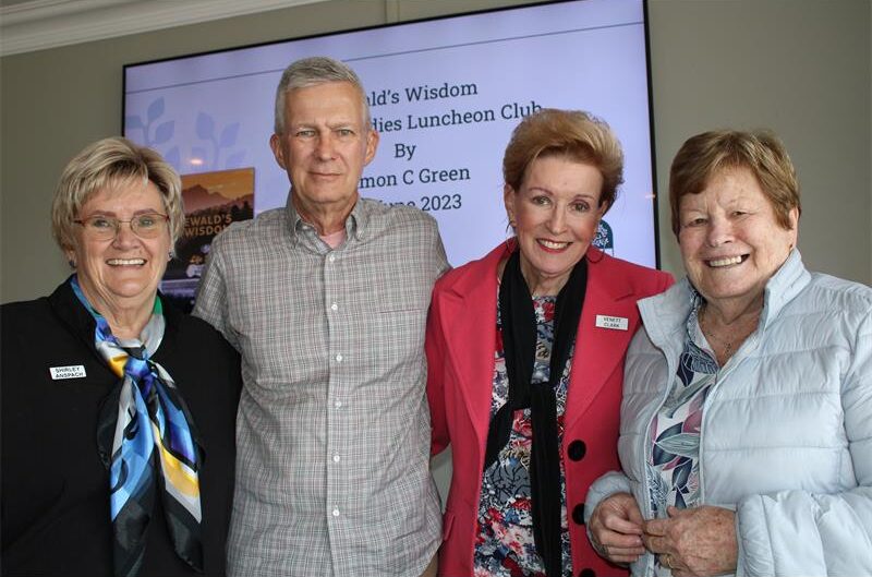 Three women smiling standing next to a man