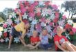 Four kids, a girl and three boys doing playful poses in front of a spring display