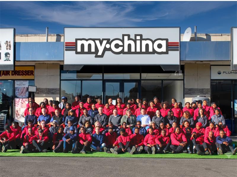 Group of people sitting outside a building with the words My China